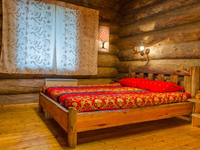 Двуспальная кровать в одной из комнат коттеджа Три медведя