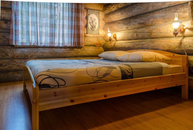 Двухспальная кровать в одной из комнат коттеджа Сказка, Малая Медвежка